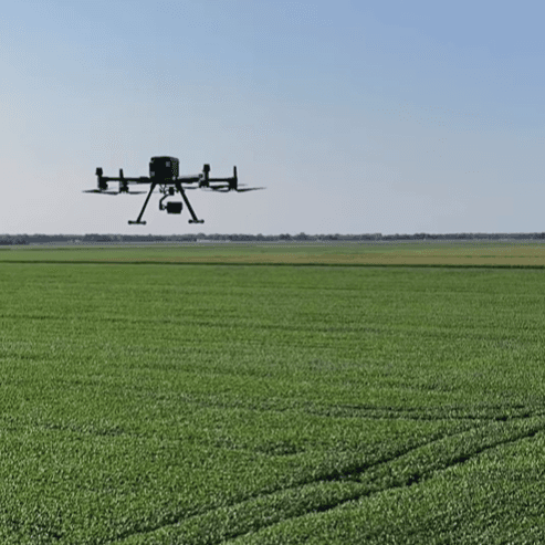 a drone flying over fields of farmland